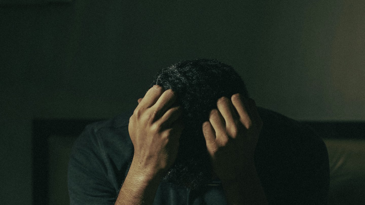 Person holding their head in their hands.